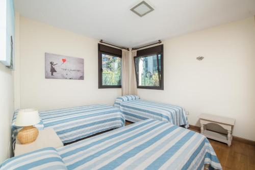 a living room with two blue and white striped couches at Apto Llanes Piscina y Playa – El Recreo de Celorio in Celorio