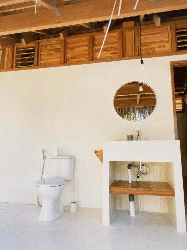 a bathroom with a toilet and a sink at Oeseli Beach Bungalow in Pulau Helihana