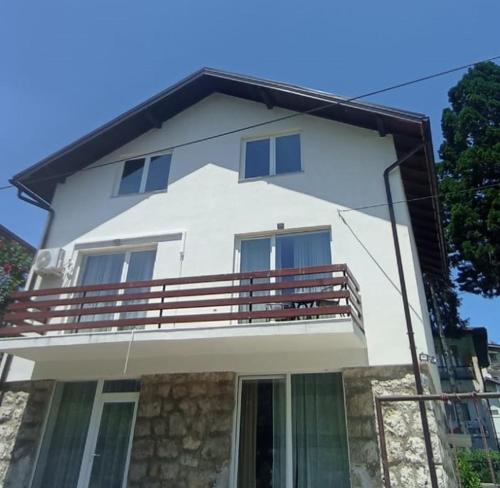 a white house with a balcony on top of it at Apartman ANNA in Jajce