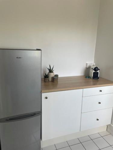 une cuisine avec un réfrigérateur et un comptoir en bois dans l'établissement PARIS Arena la Défense, à Rueil-Malmaison