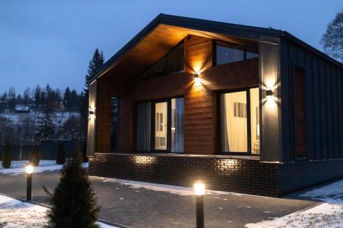 a house with lights on the side of it at Краєвид in Slavske