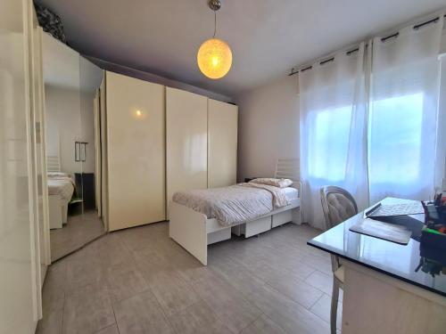 a bedroom with a bed and a desk and a window at Appartamento Cristian Zucconi in Venturina Terme