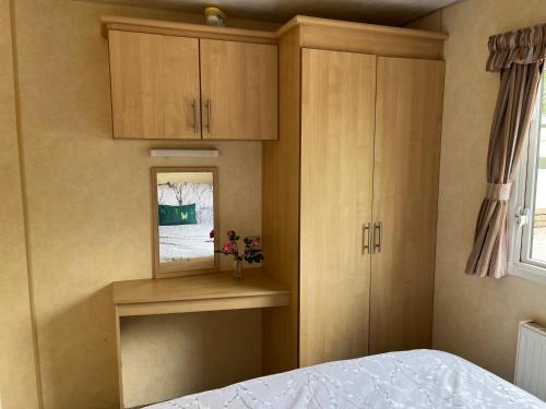 a bedroom with a bed and wooden cabinets and a window at Sylvan in Builth Wells