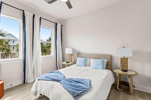 a white bedroom with a bed and two windows at Galveston Bayside Breeze Retreat in Galveston