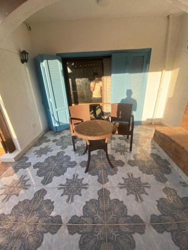 a living room with a table and chairs on a tile floor at 2BR ground chalet with private garden شاليه أرضي غرفتين بحديقة خاصة in Dawwār Ḩalīs