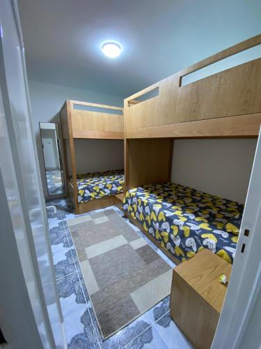 a room with two bunk beds in a room at 2BR ground chalet with private garden شاليه أرضي غرفتين بحديقة خاصة in Dawwār Ḩalīs