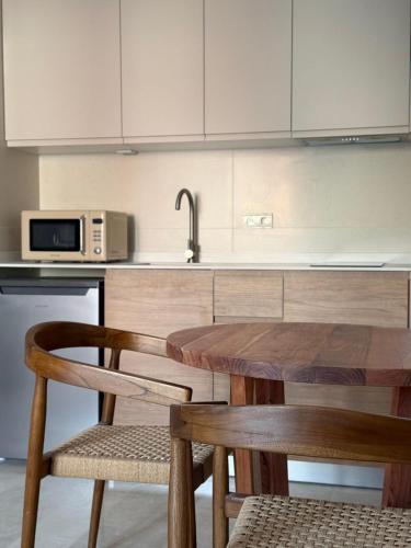 a kitchen with a wooden table and a sink at Bellver Home Apartamentos in Chella