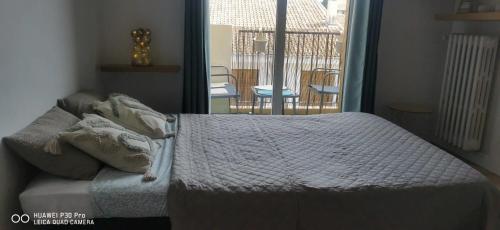 - un lit avec des oreillers dans une chambre avec une fenêtre dans l'établissement Studio cosy avec terrasse à Vallauris 15 m², à Vallauris