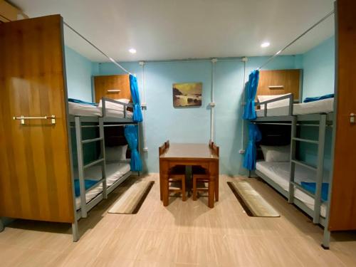 a room with three bunk beds and a table at Riverside Pak Nakon Restaurant & hostel in Ban Ko Mai Phai