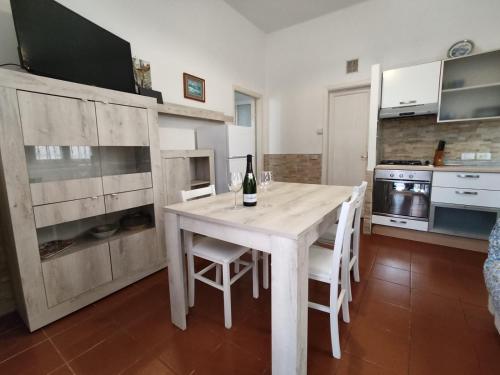 a kitchen with a table with a bottle of wine on it at Il Porticciolo di Bocca di Magra House in Bocca di Magra