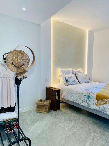 une chambre avec un lit et un chapeau sur un trépied dans l'établissement VillaM with heated pool, panoramic view, sea, à Mandelieu-la-Napoule