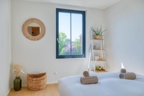 a bedroom with a bed with a mirror and a window at Beautiful 3-Bedroom Home with Garden & Parking in Deinze