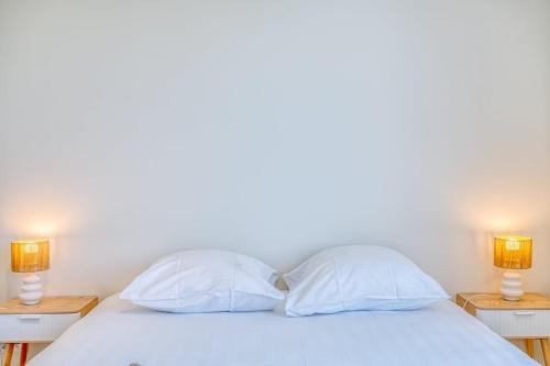 a bed with two white pillows and two lamps at Beautiful 3-Bedroom Home with Garden & Parking in Deinze