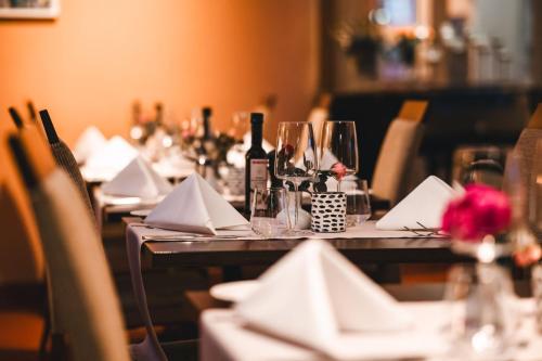 a table with glasses and napkins and wine bottles at Hotel Hüttmann in Norddorf