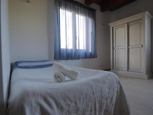 a bedroom with a white bed with a window at Le Dame Country House, Marche in Montegranaro