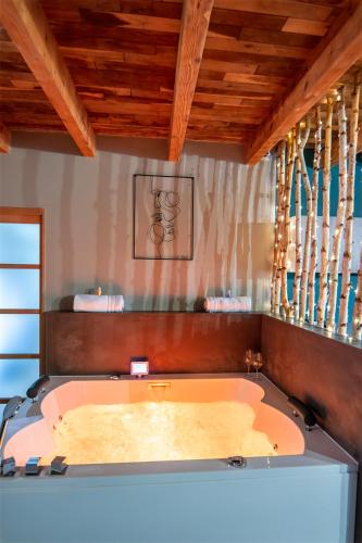 Cette chambre dispose d'une baignoire et de plafonds en bois. dans l'établissement Le Cocon du Domaine des Ecus d'Or, à Montceau-et-Écharnant