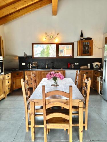 une cuisine avec une table en bois et des fleurs. dans l'établissement La villa des 3 frontières, à Porté-Puymorens