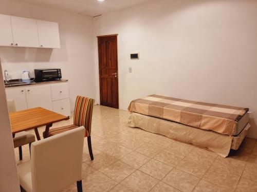 a room with a bed and a table and a kitchen at Alojamiento Almendra in Paso de los Libres
