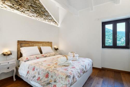 a white bedroom with a bed and a window at Cà Du Praettu in Albisola Superiore