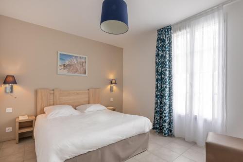 a bedroom with a bed and a large window at Résidence Odalys Rêve d'île in Rivedoux-Plage
