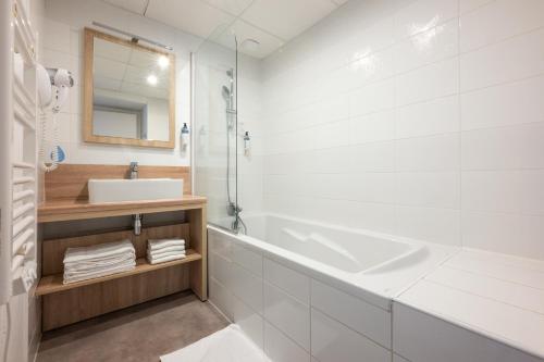 a white bathroom with a sink and a mirror at Résidence Odalys Rêve d'île in Rivedoux-Plage