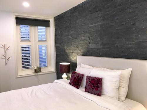 a bedroom with a white bed and white walls at Saint Tropez Boutique Hotel in Willemstad