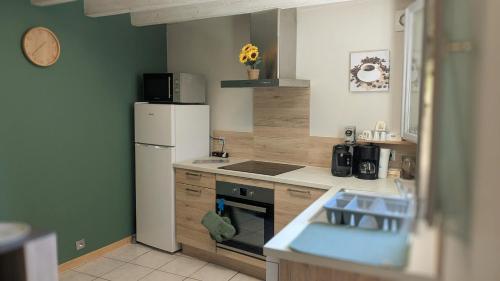 a kitchen with a white refrigerator and a sink at La Maison Du 146 in Flavin