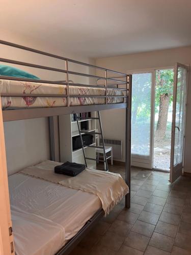 two bunk beds in a room with a window at Villa à Salazac - Piscine - Gorge de l'Ardèche in Salazac