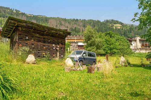 a car parked in a field next to a barn at Laugen Lodge in San Pancrazio dʼUltimo