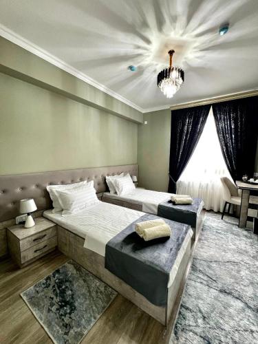 a bedroom with two beds and a chandelier at RUDAKIY Hotel in Samarkand