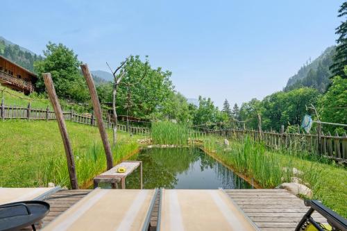 a bridge over a pond with a bench on it at Laugen Lodge in San Pancrazio dʼUltimo
