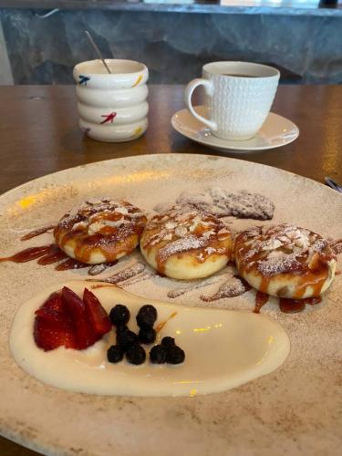 a plate with three donuts and a cup of coffee at New Gudauri Loft 1 in Gudauri