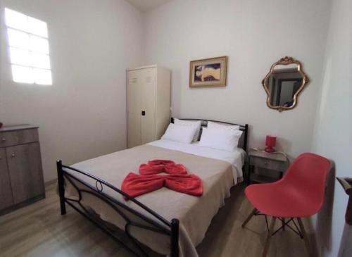 a bedroom with a bed and a red chair at Kavala Summer in Kavála