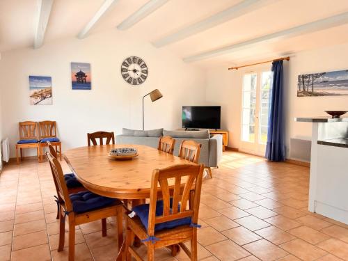 Il dispose d'une cuisine et d'un salon avec une table et des chaises en bois. dans l'établissement OPALINE maison spacieuse proche plage, à Sainte-Marie de Ré
