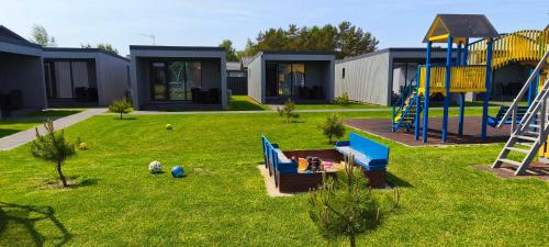 a yard with a playground with a slide at Audronašų Vilų Nameliai in Šventoji