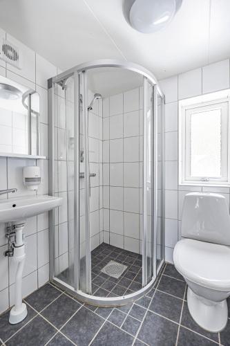 a bathroom with a shower and a toilet and a sink at Sure Hotel by Best Western Vilsta Sporthotell in Eskilstuna