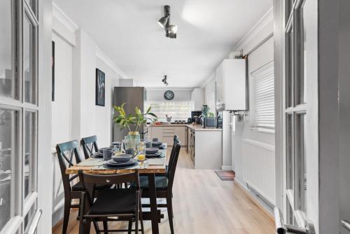 a kitchen and dining room with a table and chairs at 4BR Home Near Morriston, Swansea in Swansea
