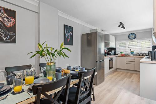 a kitchen and dining room with a table and chairs at 4BR Home Near Morriston, Swansea in Swansea