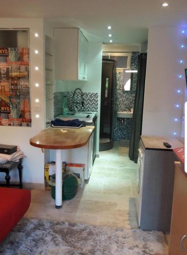 - une cuisine avec une table au milieu d'une pièce dans l'établissement Maison atypique avec Cascate Duplex plus Studio a 200 m Notre Dame Valcluse, à Auribeau-sur-Siagne