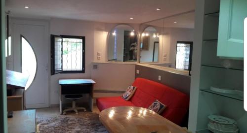 un salon avec un canapé rouge et une table dans l'établissement Maison atypique avec Cascate Duplex plus Studio a 200 m Notre Dame Valcluse, à Auribeau-sur-Siagne