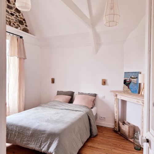 une chambre blanche avec un lit et une fenêtre dans l'établissement Villa Les Embruns, Villa balnéaire familiale, plages à pied, à Saint-Quay-Portrieux