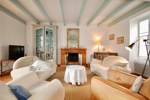 Elle comprend un salon doté d'un mobilier blanc et d'une cheminée. dans l'établissement 530 D La Petite Verrière Village house, à Saint-Martin-de-Ré
