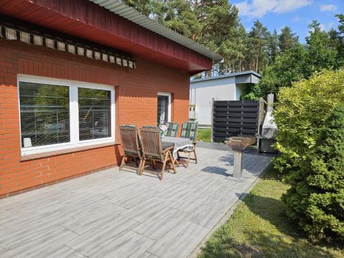 a patio with a table and chairs next to a house at Ferienhaushälfte am Fleesensee in Silz