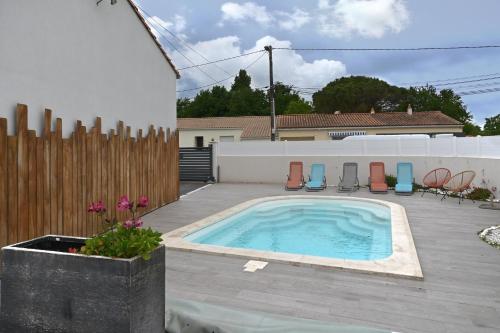 - une piscine dans un jardin avec des chaises et une clôture dans l'établissement La Vague d'Arvert - 15mn des plages, à Arvert