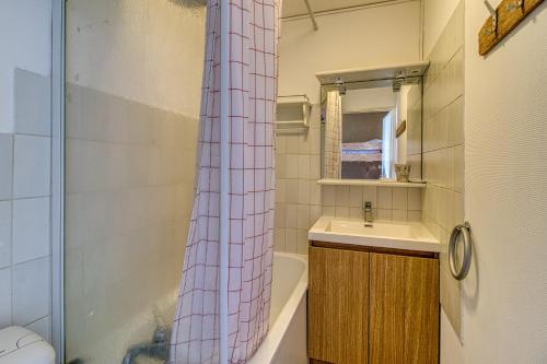 une salle de bain avec un lavabo et un rideau de douche dans l'établissement Résidence le Nautica - au pied de la plage, à Bray-Dunes