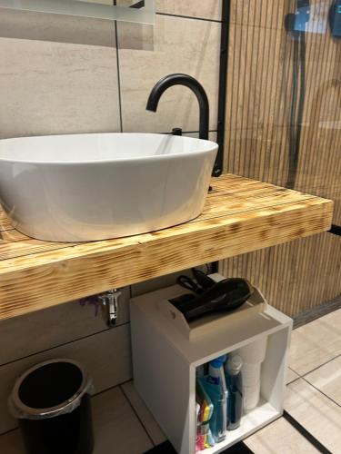 a white sink on a wooden counter in a bathroom at Anita Apartment Breitenbrunn Chill And Relax in Breitenbrunn