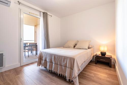 - une chambre avec un lit et une table avec une fenêtre dans l'établissement Pietra Di Mare - Au coeur d'Ajaccio, à Ajaccio