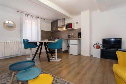 une cuisine et un salon avec une table et des chaises dans l'établissement Le Studio des Songes - proche de la gare, à Riorges