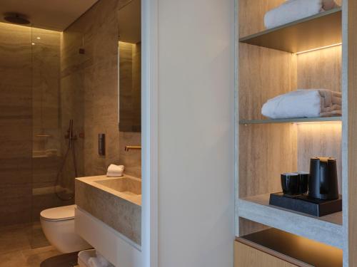 une salle de bain avec un lavabo, des toilettes et une douche dans l'établissement Nur Riviera Aparthotel, à Athènes
