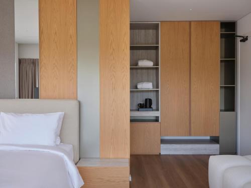 a bedroom with a bed and a cupboard at Nur Riviera Aparthotel in Athens